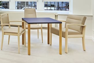 Vierkante vergadertafel met donkerblauwe tafelblad en houten poten, omringd door drie beige stoelen met houten armleuningen i