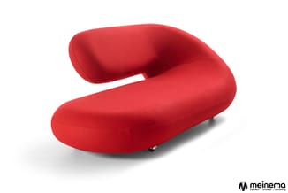 Rode gebogen loungefauteuil met gladde stof bekleding en wieltjes, zijkant weergegeven tegen witte achtergrond.