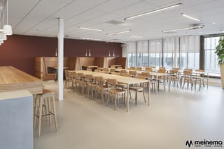 Modern kantoor met houten eettafels, houten stoelen, bruine wandpanelen, hangende witte lampen, grote ramen en witte plafondv