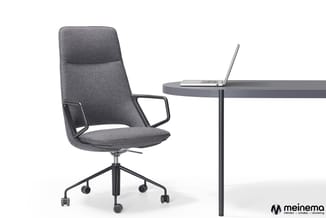 Grijze bureaustoel met armleuningen en zwart onderstel op wielen, naast ronde grijze tafel met laptop. Meinema-logo rechtsond