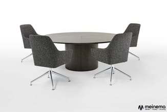 Ronde grijze vergadertafel met donker houten voet en vier grijze stoelen met aluminium kruispotenonderstel.