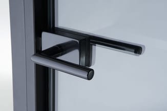 Moderne zwarte deurklink op grijs deurframe, minimalistische architectonische details