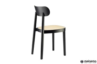 Zwarte houten stoel met ronde zitting in rotan en gebogen rugleuning tegen witte achtergrond.