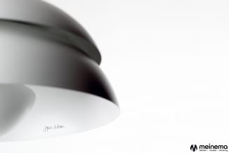 Hangende ronde plafondlamp met grijs-zwarte afscherming en wit binnenoppervlak, ontwerp John Woan, meinema-logo.
