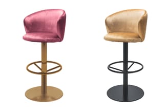 Twee barkrukken met gewelfde rugleuning: links roze fluweelachtig model op goudkleurige poot, rechts beige variant op zwarte