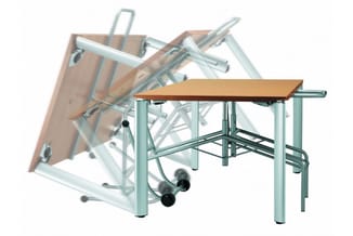 Opklapbare vergadertafel met houten blad en metalen frame, gesloten klapstoel op wielen op de achtergrond.