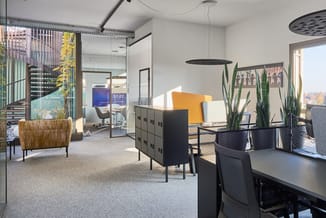 Modern kantoor met zwarte vergadertafel, gele en witte stoelen, zwarte kasten, rieten fauteuil, hangende verlichting en grote