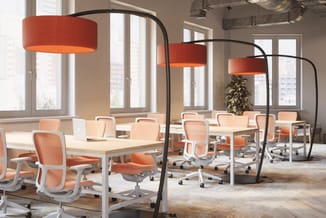Modern kantoor met oranje bureaustoelen, natuurhouten tafels, zwarte booglampen met rode kappen en grote ramen met uitzicht o