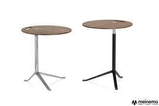 Twee ronde houten bistrotafels met chromen en zwarte poten op wielbasis, met kabelgaten in het tafelblad.