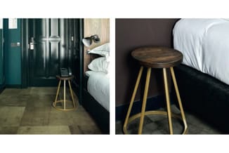 Twee afbeeldingen van een bijzettafel met donkerbruin houten blad en goudkleurig metalen poten, geplaatst naast een bed met z