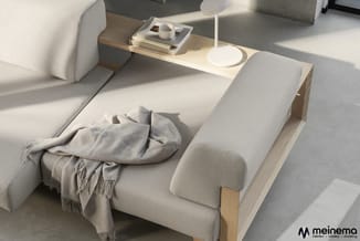Beige loungebank met houten armleuningen, gezelschapstafel met lamp en boeken, beige plaid, minimalistisch interieur.