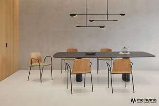 Moderne vergaderkamer met zwarte tafel, houten stoelen met zwarte poten, hangende zwarte design-pendellampen en houten wand.