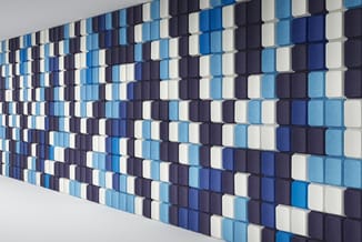 3D wandpanelen in blauw, wit en zwart met ruitpatroon, gekromd op witte wand gemonteerd.
