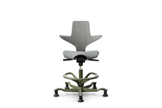 Ergonomische zit-sta stoel met grijze zitting, groene voetsteun en zwarte wielen op wit oppervlak.