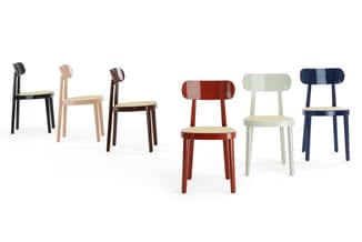 Zes houten stoelen in verschillende kleuren: zwart, naturel, donkerbruin, rood, groen en donkerblauw, elk met hout zitting en
