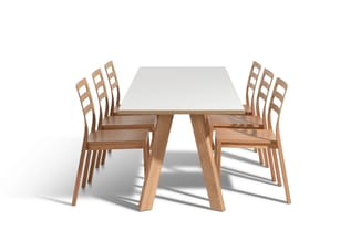 Houten vergadertafel met witte blad en 6 houten stoelen met rugleuning, gerangschikt op witte achtergrond.