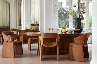 Moderne eetkamer met houten tafel, terracottarode stoelen met organische vormen, grote ramen, groene planten en minimalistisc