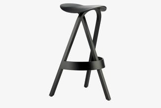 Zwarte houten barstoel met ergonomisch gevormd zitgedeelte, X-vormig frame en voetsteun.