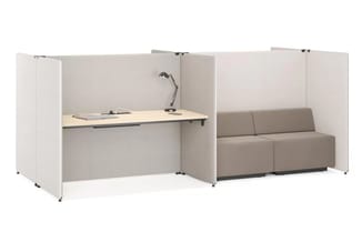 Lichtgrijze MySpace schermen rondom een bureau met zwarte bureaulamp en een aangrenzende taupekleurige tweezitsbank.