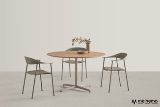 Ronde houten eettafel met kruispoot in natuurtint, omringd door drie grijsgroene stoelen met armleuningen en zitting. Minimal