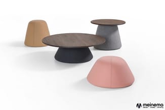 Modulaire zitpoefs en salontafels in verschillende kleuren: beige, grijs, zwart en roze, met donkerhouten tafelbladen.