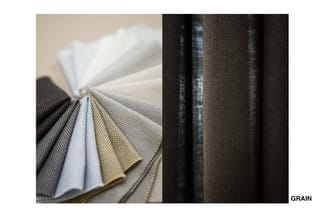 Stofstalen in verschillende kleuren en texturen, waaronder zwart, wit, grijs en beige weefsel. Rechts detail van de weefstruc