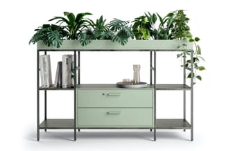 Grijs metalen kastencombinatie met groene laden, plantenbak bovenop, boekenplank en decoratieve items.