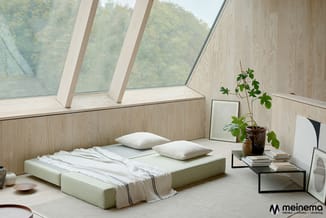 Minimalistisch slaapkamerconcept met twee laagliggende bedden in wit/crème, houten wandbekleding, schuine ramen, en zwart met