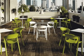 Dakterras met groen-gele kunststof stoelen rond witte en zwarte tafels, hangende witte lampen, groene planten, uitzicht op st