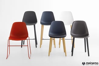 Collectie van vijf moderne stoelen in verschillende kleuren en uitvoeringen: rood met metalen frame, grijs gestoffeerd, marin