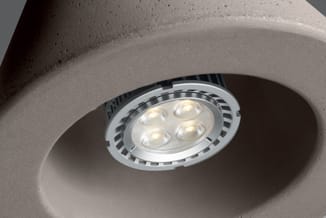 LED-inbouwspot met vier lichtpunten in ronde betonnen plafondafwerking, wit en zwart design.
