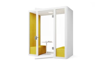 Witte akoestische belcel met gele binnenkant, open deur, zitbank, tafelblad en ledverlichting.