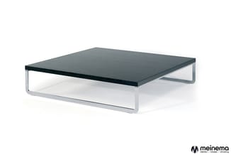 Lage salontafel met zwart blad en gebogen metalen onderstel in zilvergrijs, vrijstaand getoond.