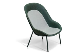 Groene loungefauteuil met lichtgrijs zitgedeelte, gesloten rugsteun en zwarte metalen poten op witte achtergrond.