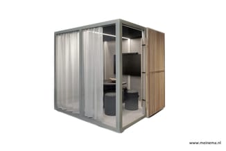 Grijze belcel met glazen deur, witte gordijnen, houten latten zijwand, grijze stoelen en tafel binnen.