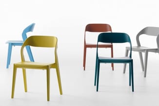 Vijf moderne stoelen in verschillende kleuren (geel, blauw, bordeaux, donkergroen, grijs) tegen witte achtergrond.
