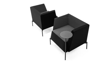 Twee zwarte fauteuils met metalen poten, één met grijze zitting en rond grijs tafelblad, in isometrisch perspectief.