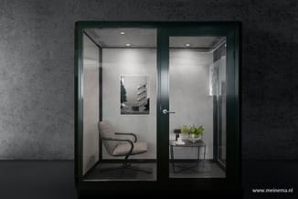 Twee moderne kantoorbelcellen met donkergroen aluminium frame en glaswanden. Links een grijze bureaustoel en architectuurfoto