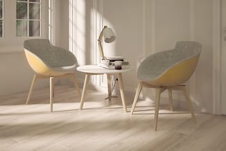 Twee grijsgroene fauteuils met geel/naturel houten frame rond een witte ronde tafel in een lichte kantoorruimte met raamparti