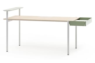 Strak bureau met lichte houten blad, witte poten, groen-grijs ladekastje op rechts en verstelbare tafelpanelen links.