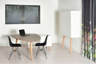 Moderne kantoorruimte met grijze ovale tafel, twee zwarte stoelen met metalen onderstel, laptop, witte kast, jaloeziëën en go