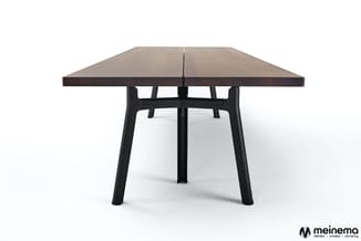 Moderne vergadertafel met donkergrijs blad en zwart stalen onderstel met vier poten, vrijstaand tegen witte achtergrond.