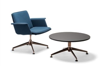 Blauwe kantoorstoel met armleuningen en ronde grijze tafel op wielbasis, beide met bronzen poten.