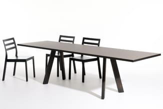 Zwarte vergadertafel met grijze tafelblad en vier zwarte stoelen met ladderrug, op wit oppervlak.