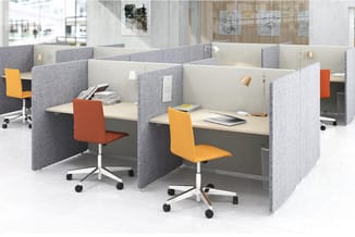 Kantoorwerkplekken met grijze geluidswallen, beige bureaubladen, rode en gele bureaustoelen, hangende verlichting in moderne