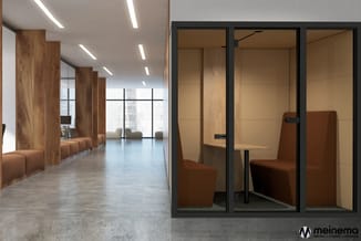 Moderne kantoorruimte met houten zuilen, glazen belcel met zwart frame, bruine fauteuils en houten werkblad.