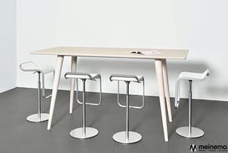 Houten vergadertafel met witte poten en vier witte barkrukken met metalen onderstel in kantooromgeving.