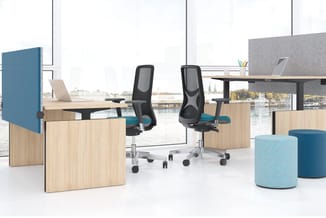 Modern kantoorrecreatieruimte met houten werkplekken, zwarte ergonomische bureaustoel, blauwe akoestische schermen, lichtblau