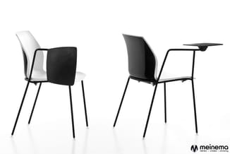 Twee moderne stoelen met zwart metalen frame en witte kunststof zitting. Rechts een stoel met uitklapbaar zwart schrijftablet