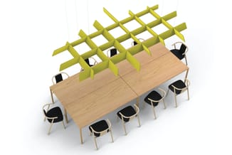 Houten vergadertafel met zwarte stoelen en geel-groene lattenwand als akoestische scheiding.